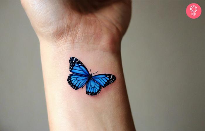 A blue monarch butterfly tattoo on a woman’s wrist