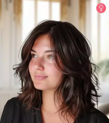 A woman with a red-colored fluffy pixie haircut