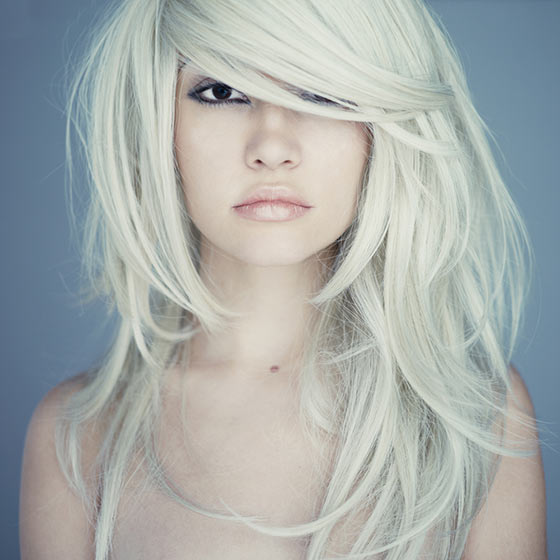 Platinum blonde layers with side swept bangs hairstyle for a square face