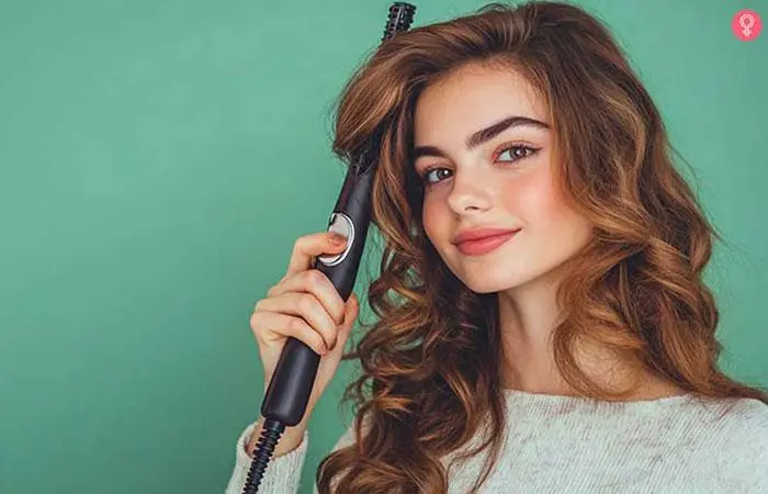 A woman using a wand to create curls