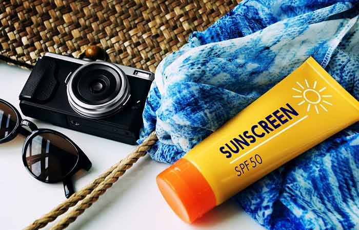 An image with a sunscreen glasses sling bag scarf and camera