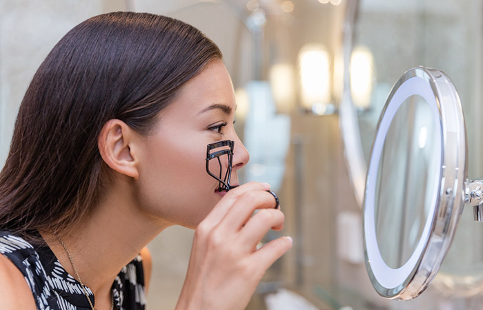 Woman using eyelash curler can thin the layer