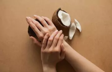 Beautiful female hands over coconuts