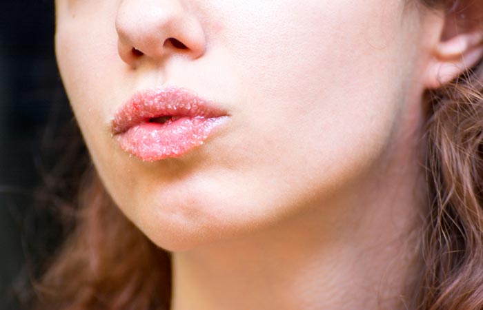 A woman exfoliating her lips with a homemade lip care recipe