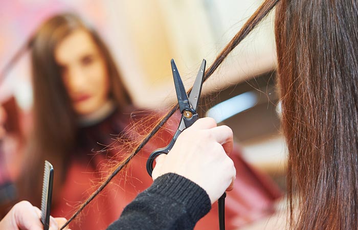A professional hair dresser trimming split ends using the hair twisting method