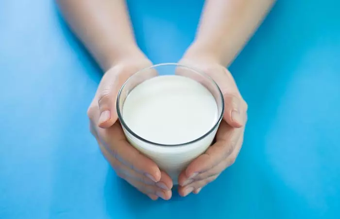 Hands holding a glass of milk