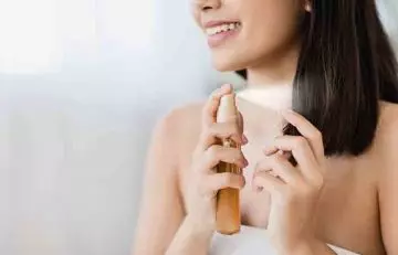 Woman using a glossy spray on her hair to give it that extra shine