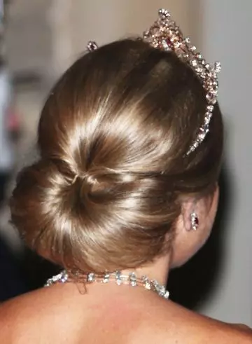 Polished low semi circular bun with volumized crown hairstyle for wedding season