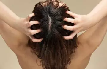 Woman giving herself a scalp massage