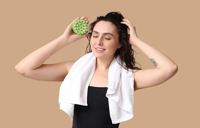 Woman using a scalp massage brush