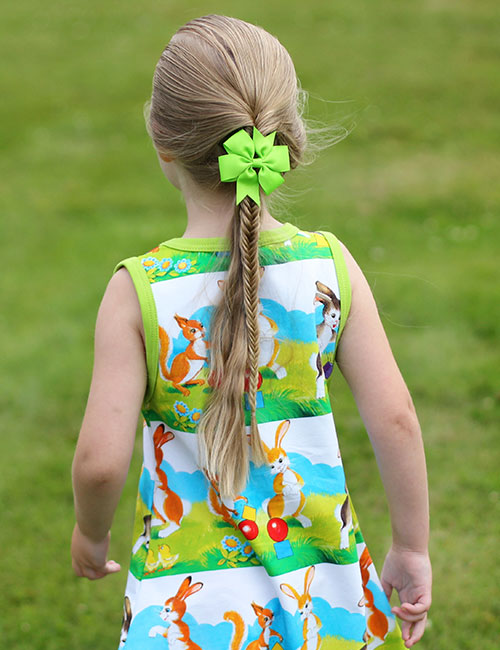 A small girl with a accentuated fishtail and a bow