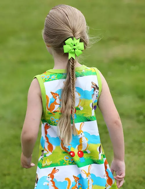 A small girl with a accentuated fishtail and a bow