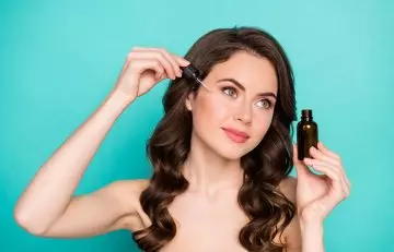 Woman applying vitamin e oil to prevent dry skin around eyes