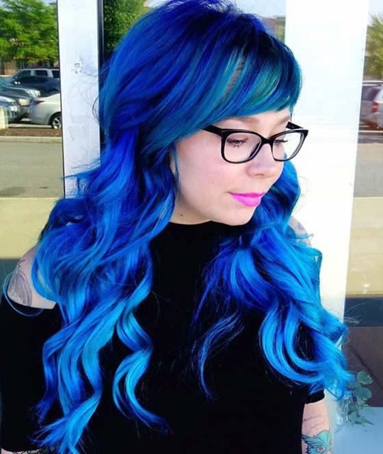 Electric blue curls and side swept fringe layered hairstyle