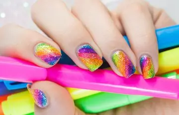 A woman with neon glitter nails