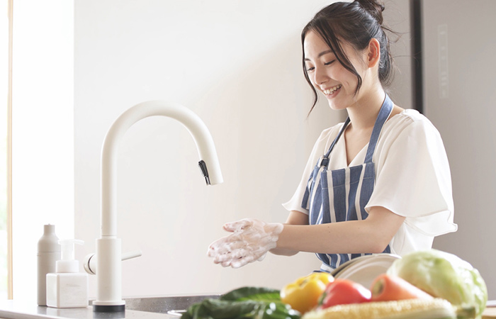Woman washing hands before preparing food to stay healthy