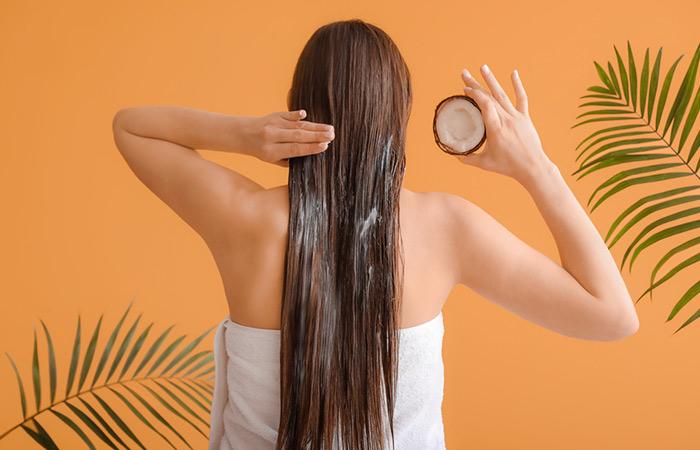 Woman oiling her hair with coconut oil