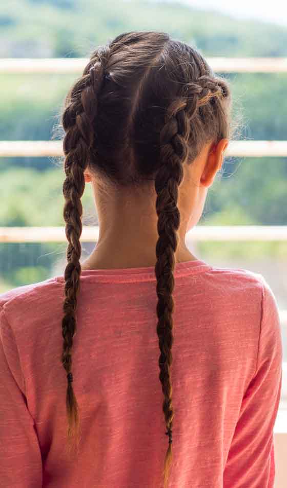 A young girl sporting a two-side pigtail dutch braid school hairstyle