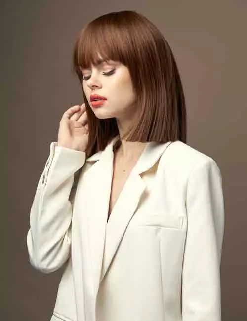 A woman sporting a shoulder-length bob with bangs