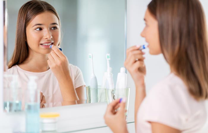 Teenage girl applying lip balm