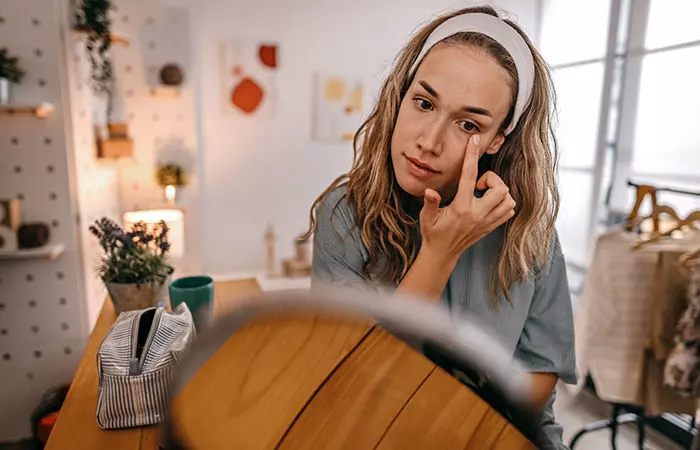 Woman applying vaseline to remove eye makeup