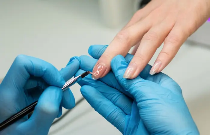 A woman applying nail extensions