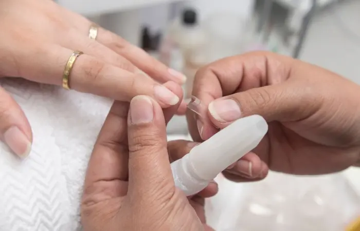 A woman applying nail extensions