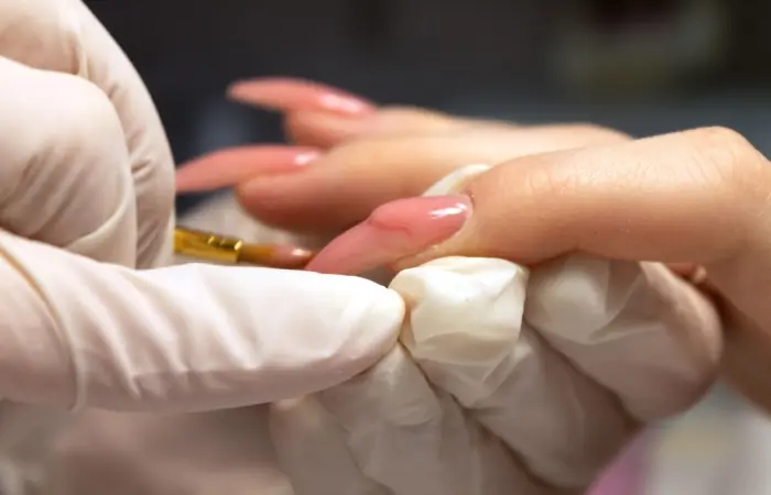 A woman applying nail extensions