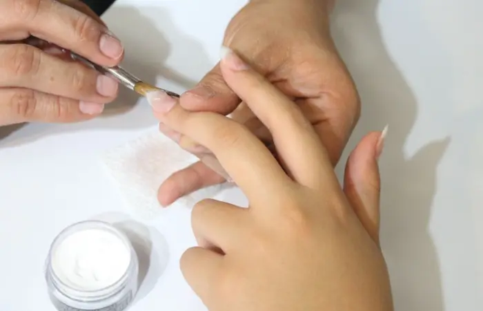 A woman applying nail extensions