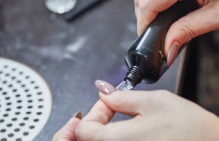 A woman applying nail extensions