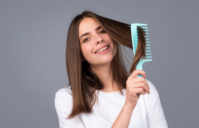 Woman uses wide-toothed comb on rebonded hair