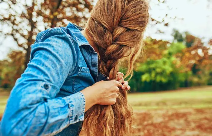 A woman braiding her hair