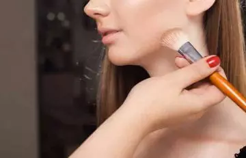 Woman applying loose compact powder