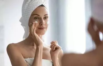 Woman moisturizing her face after cleansing