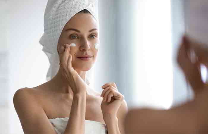 Woman moisturizing her face after cleansing