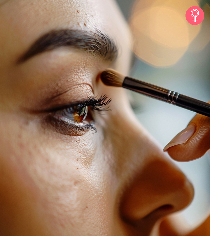 Girl applying mascara in front of a mirror