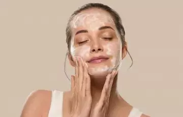 Woman washing her face with facial cleanser