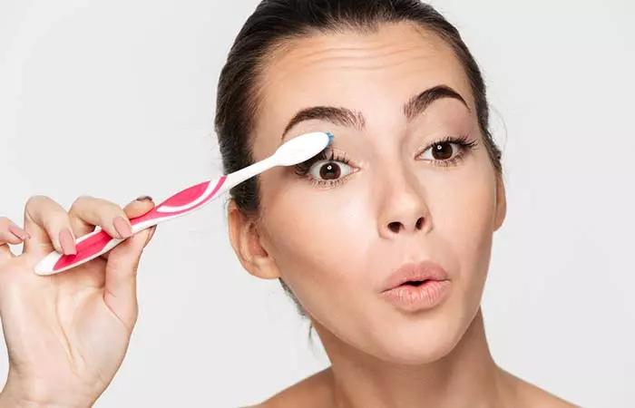 Curl your eyelashes using a warm toothbrush