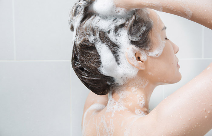 Woman using a clarifying shampoo to get rid of the grease in her hair