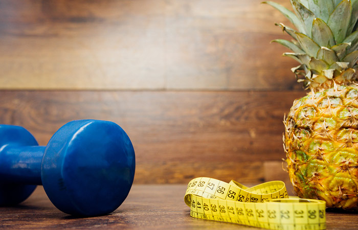 Pineapple with dumbbells and measuring tape