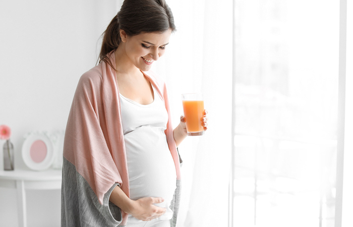 A pregnant woman drinking carrot juice