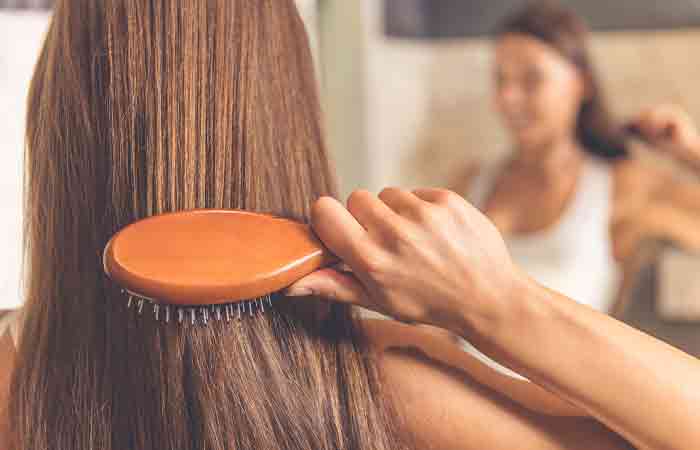 Woman combing her long hair after using cinnamon