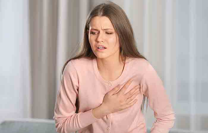Woman with a hand on chest to show poor heart health