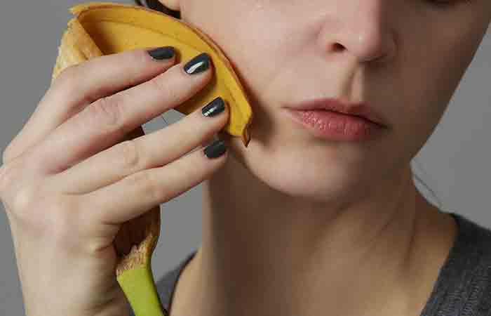 Woman rubbing banana peel on insect bite