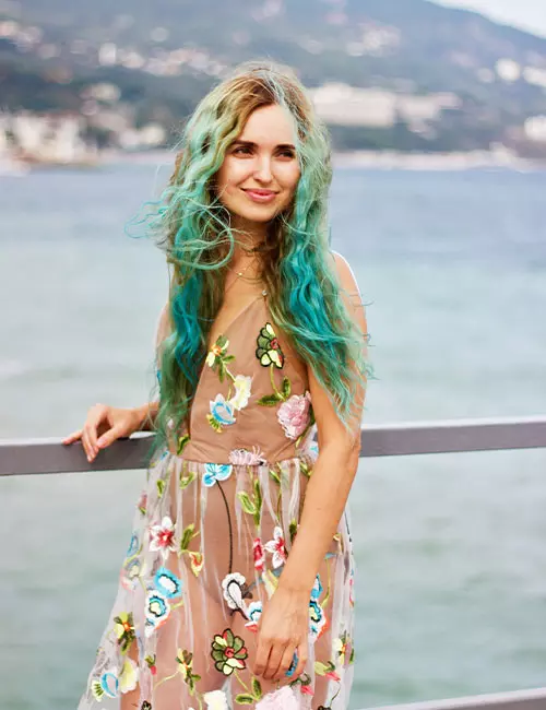 A woman with mermaid hair posing by the sea