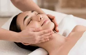 Woman getting a facial massage at a spa