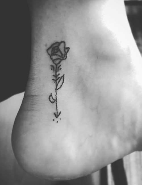 A single rose tattoo with the stalk and two leaves