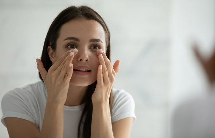 Woman applying coconut oil as under-eye cream