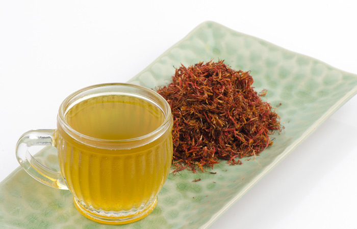 A tray with a cup of liquid saffron and a handful of dried saffron