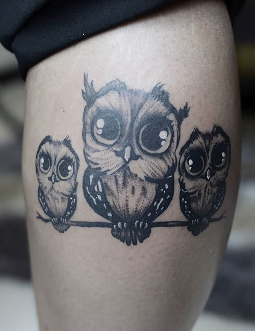 Tattoo of three owls perched on a branch